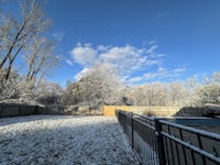 a backyard covered in snow with a fence